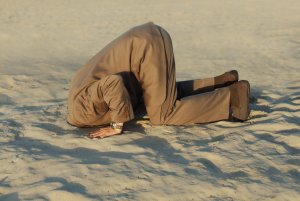 business man with his head buried in the sand